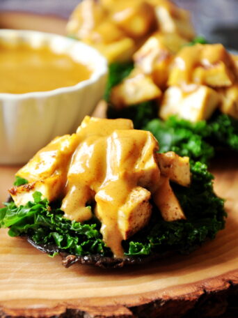 Stuffed portabella mushrooms with baked tofu and crunchy kale drizzled with a creamy cajun dressing for the win! They are vegan and gluten-free!