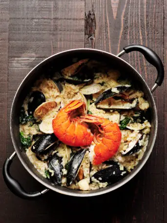 Creamy seafood risotto recipe dedicatedly simmered in lobster stock and heavy cream with clams, mussels, bay scallops, lobster tails, and spinach. It's a perfect date-night-in dinner or for any special occasions.