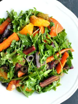 Boldly spiced sous vide carrot salad tossed with oranges and salty olives. It's a refreshing, satisfying, and stunning Moroccan-flavored dish with rainbow colors.