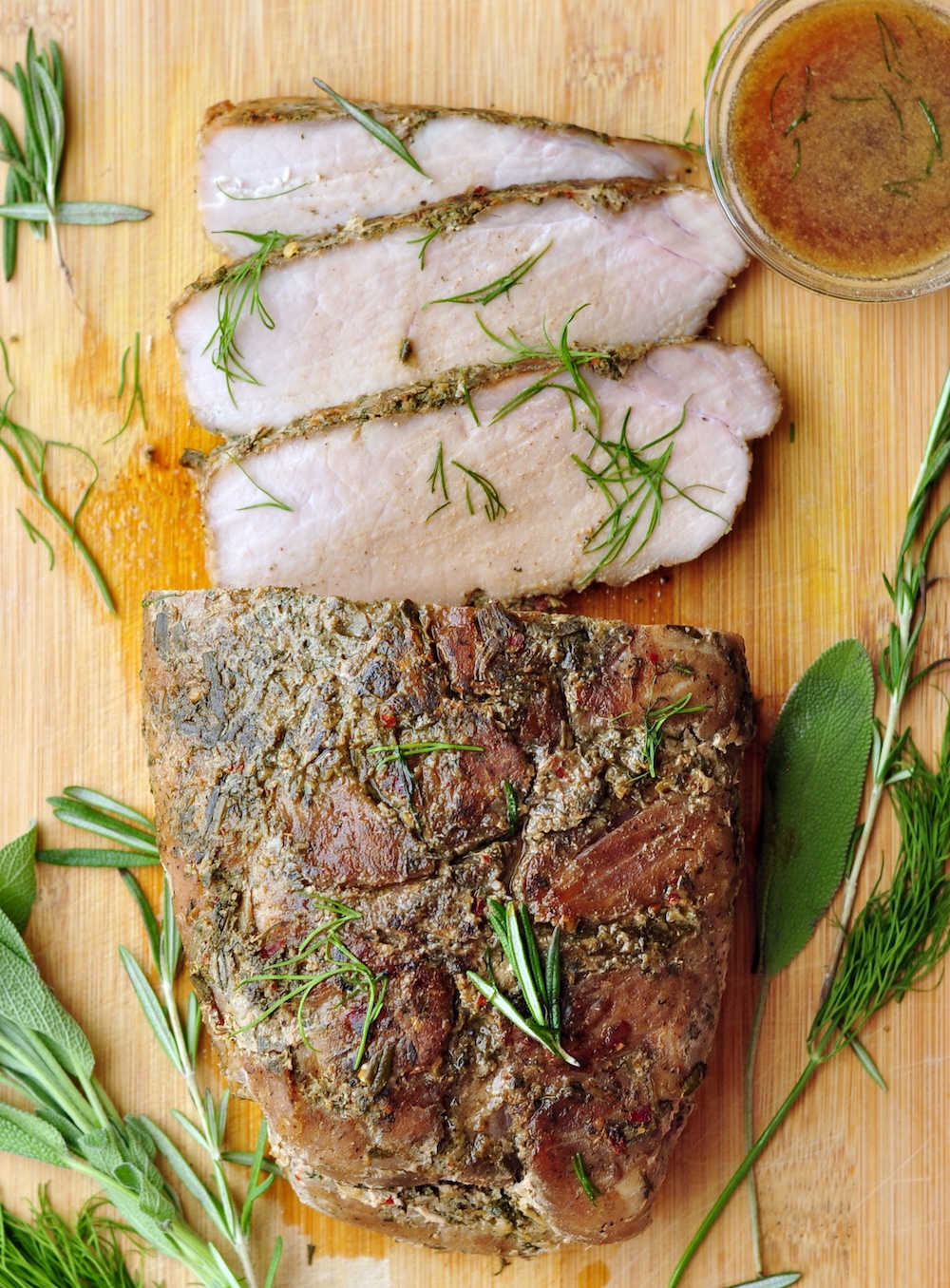 Slice the sous vide pork loin into thick slices, garnish with fresh herbs, and drizzle with the serving sauce before serving.