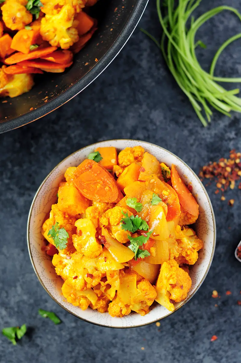 Thai red curry vegetables featuring cauliflower, sweet potatoes, carrots and onions cooked with white wine and simmered in coconut milk.